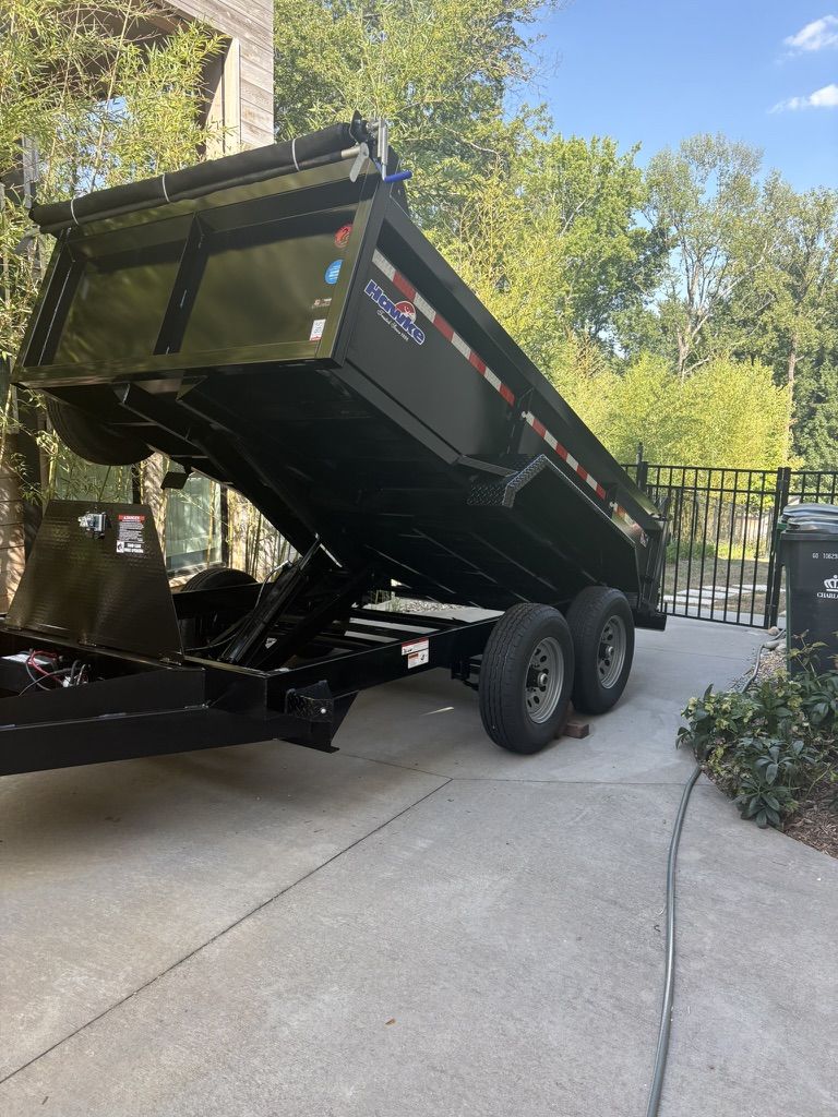 Black dump trailer raised in a driveway