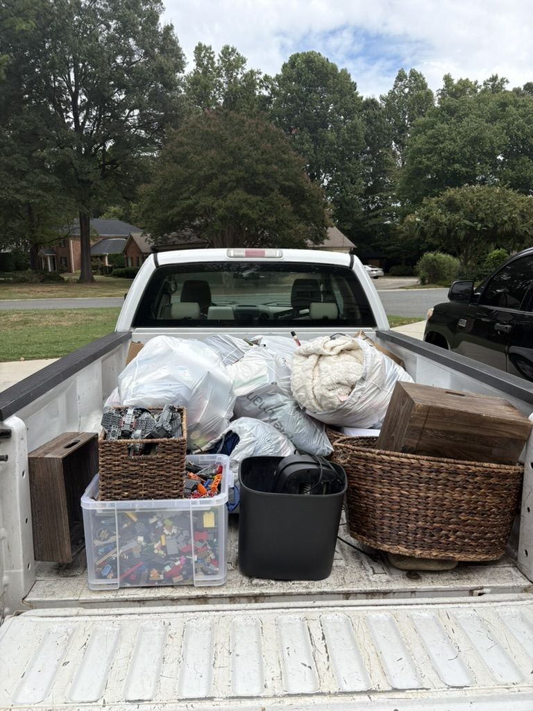 Truck bed loaded with bags, bins and baskets from a cleanout